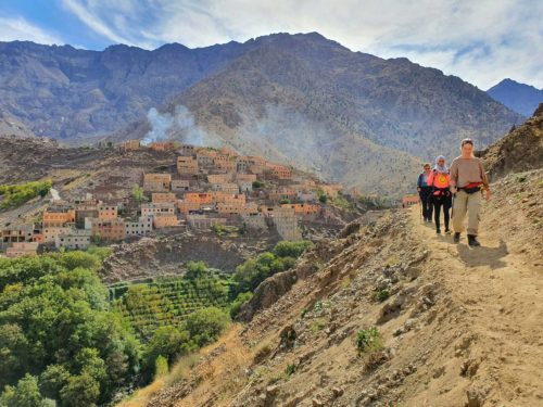 Drie wandelaars op de rotsachtige pelgrimsroute naar Sidi Chamharouch in het Atlasgebergte, Marokko.