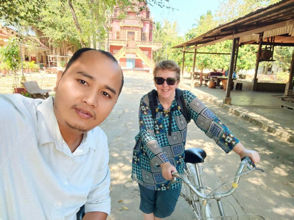 Op de fiets op het terrein van de pagode in het dorp Odambang, Cambodja