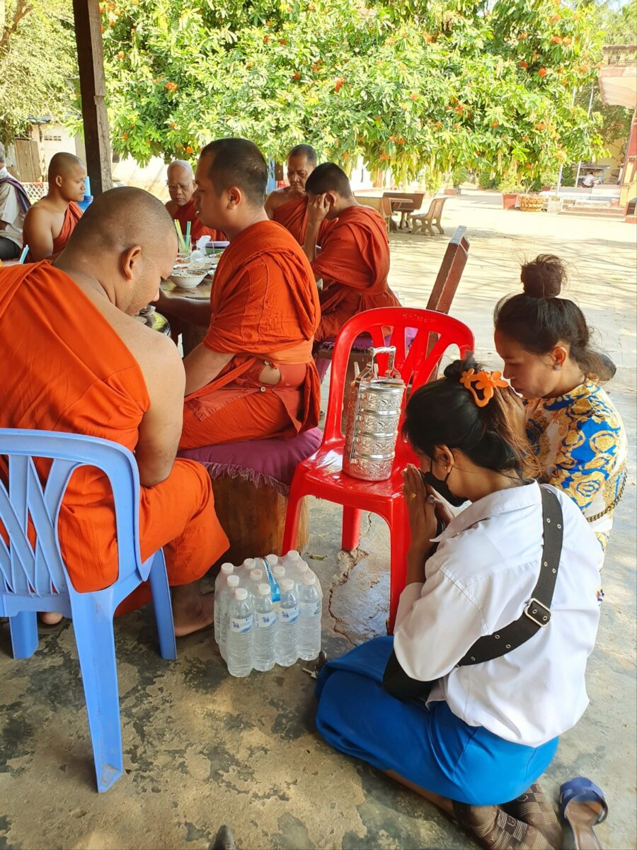 Vrouwen brengen eten en drinken bij de monniken van de pagode in Odambang, Cambodja