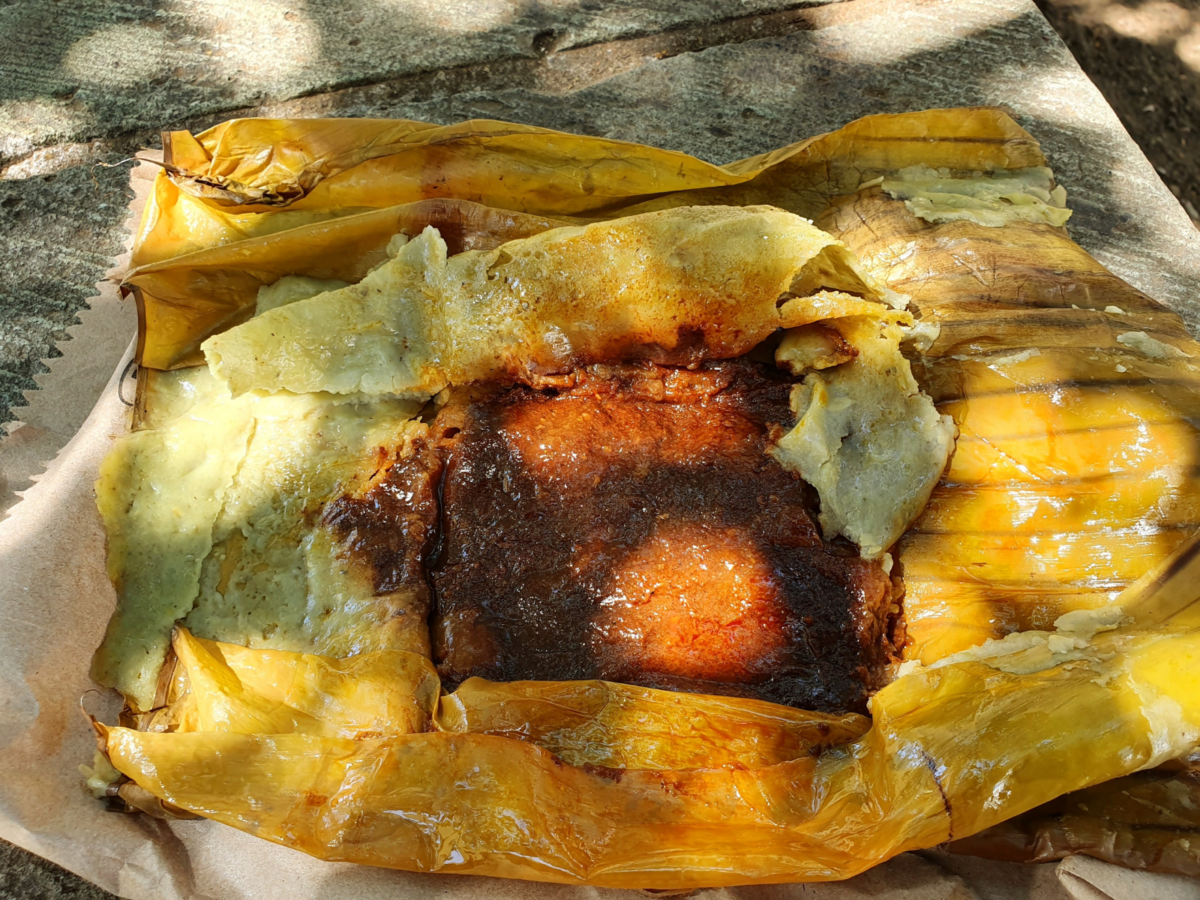 Mexicaanse tamale, een in bananenblad gestoomde maïsdeegrol met vlees in saus
